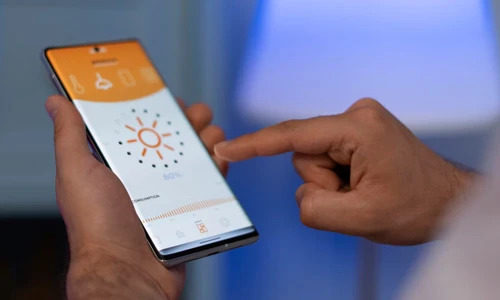 Hand holding smartphone at home