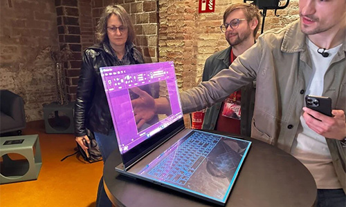 Man placing his hands behind the transparent display laptop