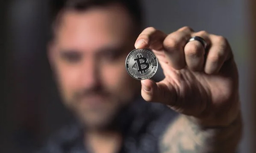 Man holding a bitcoin in hand