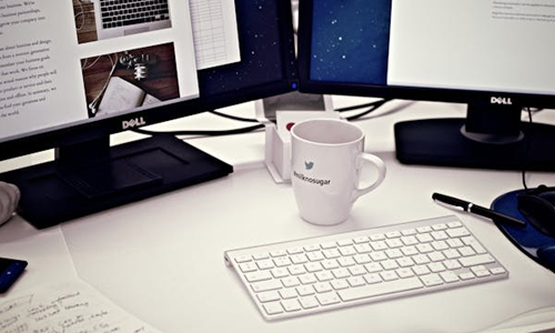 Two dell monitors and a coffee mug in a desk