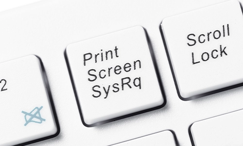 An extreme close-up showcases the pristine white keys of a computer keyboard, with black text indicating various functions like 'Print Screen,' 'Scroll Lock,'