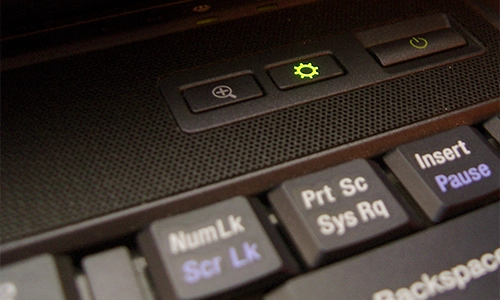 Macro shot of a laptop keyboard and power button. The laptop is gray and black