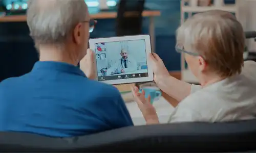 Senior couple attending a telehealth appointment through a digital tablet